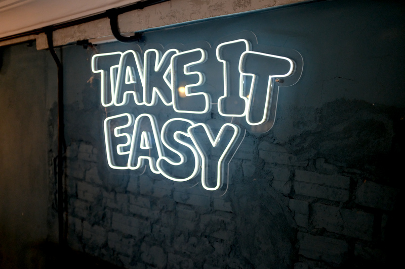 Neon sign at Sundays restaurant that reads &ldquo;Take it Easy&rdquo;